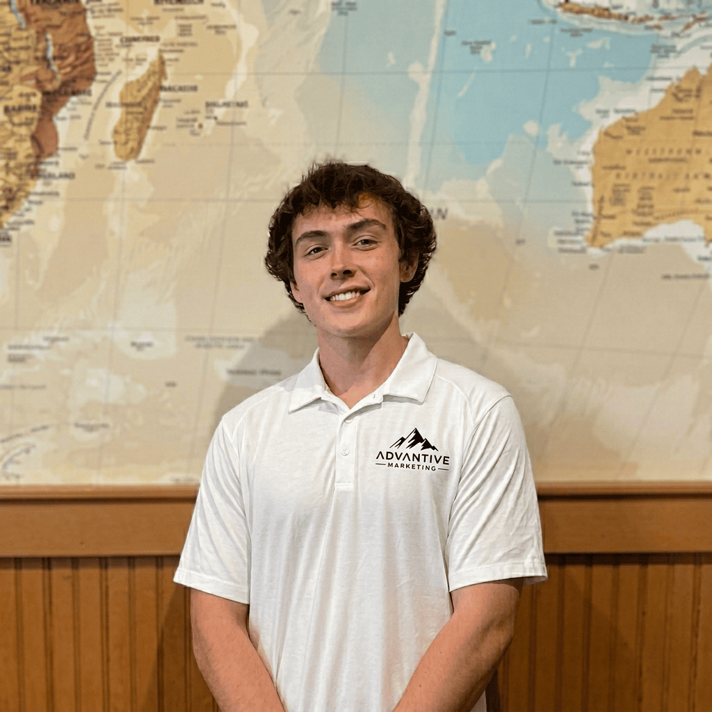 Advantive Marketing founder wearing a branded polo in front of a world map